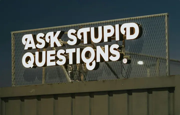 A sign that displays, "ASK STUPID QUESTIONS."