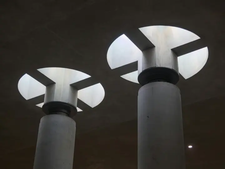 Black and white photo of circular skylights above two columns.