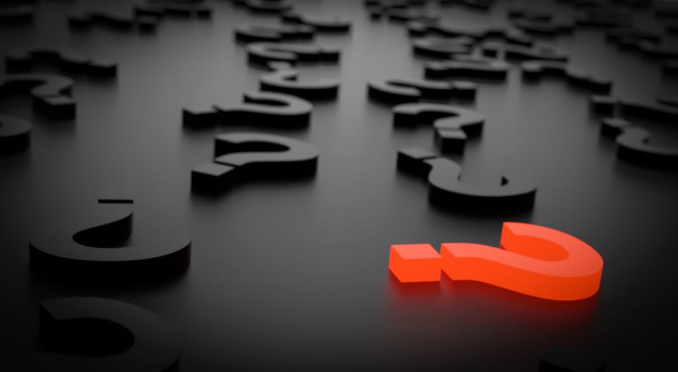 Black question marks on a black surface with a neon red question mark in the lower right corner.